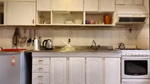 eine Küche mit weißen Schränken und einer Spüle in der Unterkunft Casa Colibrí in La Cieneguita