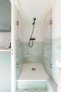 a shower in a bathroom with green tiles at Appartement moderne in Marseille