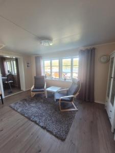 een woonkamer met twee stoelen en een tafel bij Ferienhaus Solli Norwegen inkl Boot in Kolvereid