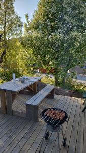 a picnic table and a grill on a wooden deck at Ferienhaus Solli Norwegen inkl Boot in Kolvereid