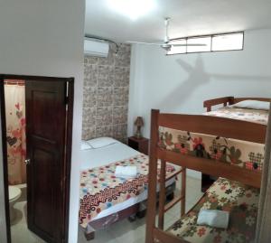 a small room with two bunk beds and a staircase at Hostal Casa Taisha in Montañita