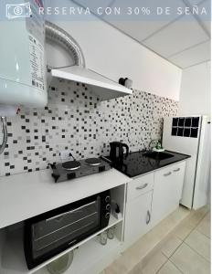 a white kitchen with a stove and a sink at Residencia Céntrica in Chilecito