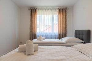two beds in a room with a window at Mega Lux Apartment in Esslingen