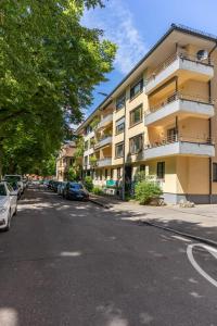 an apartment building on a street with parked cars at Mega Lux Apartment in Esslingen