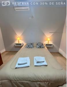 duże łóżko w pokoju z dwoma lampami w obiekcie Residencia Céntrica w mieście Chilecito