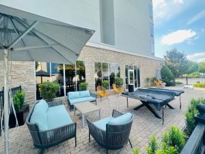 een patio met een tafel en stoelen en een parasol bij Delta Hotels by Marriott Colonial Heights in Colonial Heights