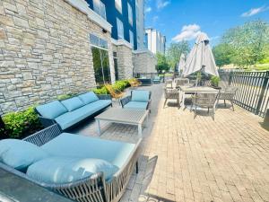 een patio met blauwe banken, tafels en stoelen bij Delta Hotels by Marriott Colonial Heights in Colonial Heights