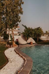 a swimming pool next to a resort with trees and water at Maya pool & mountain view villa in Koskinou +37 photos