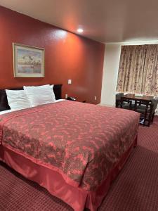 De Queen的住宿－Western Plaza Inn，酒店客房,配有一张红色床罩的床
