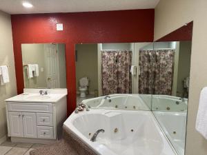 a bathroom with a white tub and a sink at Western Plaza Inn in De Queen
