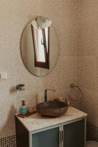 a bathroom with a sink and a mirror on the wall at Maya pool & mountain view villa in Koskinou