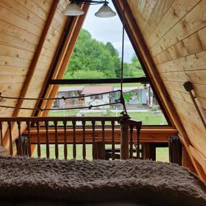 a bedroom with a large window in a log cabin at Casa de poveste A Frame in Gura Humorului