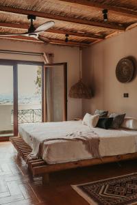 a bedroom with a large bed and a large window at Maya pool & mountain view villa in Koskinou
