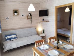 ein Wohnzimmer mit einem Sofa und einem Tisch in der Unterkunft Domki na Leśnej in Ustronie Morskie