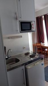 a small kitchen with a sink and a microwave at Hyper centre Strasbourg in Strasbourg