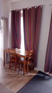 a wooden table and chairs in a room with a window at Hyper centre Strasbourg in Strasbourg +4 photos