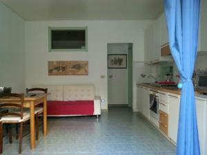 a kitchen and a living room with a couch and a table at Appartamento Gna Turidda in Ragusa