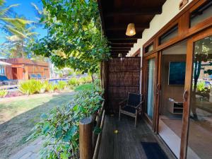 un porche de una casa con una silla en Dreamland Bungalows - Taipú de Fora - Barra Grande, en Barra Grande