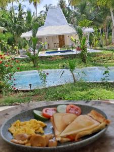 un piatto di cibo su un tavolo di fronte a un resort di The Palms Penida a Toyapakeh