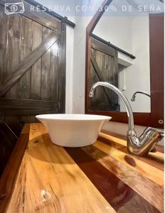 a bathroom with a white bowl sink on a wooden floor at Residencia Céntrica in Chilecito