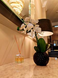 un vase de fleurs sur une table avec une lampe dans l'établissement Frederick House Hotel, à Édimbourg