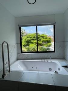 a white bath tub in a bathroom with a window at Hotel Casa Kreenty in Cali