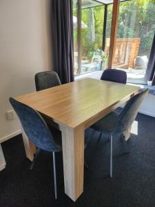 a wooden table with chairs in a room with a window at Million dollar view in Queenstown +10 photos