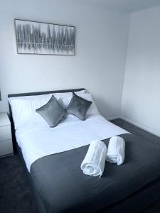 uma grande cama branca com duas almofadas em Lovely 2 Bedroom House em Cheshunt