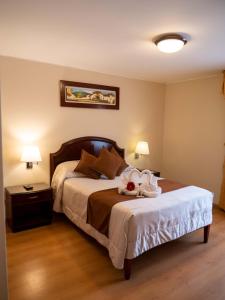 a bedroom with a bed with towels on it at Hotel Britania San Borja in Lima