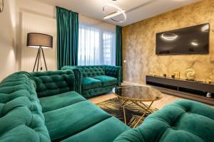 a living room with a green couch and a table at B-Holiday Luxury Apartments in Braşov