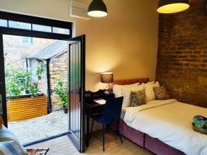 a bedroom with a bed and a desk and a window at Cotswold Bankview in Moreton in Marsh