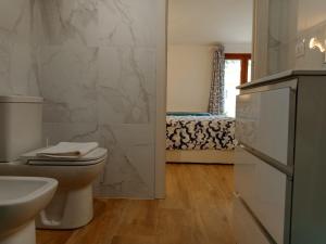 uma casa de banho com um WC e um lavatório em La Grotta em Urzulei