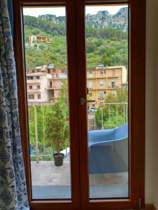 a glass door with a view of a city at La Grotta Sardegna 5 Bedrooms each with a Private Ensuite Bathroom featuring a Hydromassage Shower Air Conditioning in Urzulei