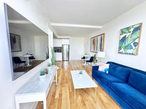 a living room with a blue couch and a table at Large One Bedroom - Massive Private Terrace - Luxury Building - Williamsburg - Greenpoint in Brooklyn