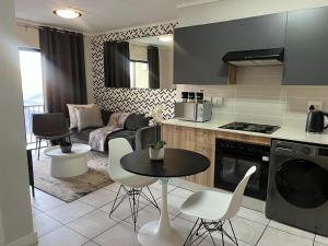 a kitchen and living room with a table and chairs at The Lagoon Exquisite Apartments in Pretoria