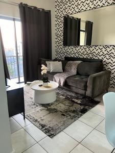 a living room with a couch and a table at The Lagoon Exquisite Apartments in Pretoria