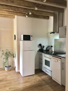 een keuken met een witte koelkast en een magnetron bij VerOliv : Superbe appartement rénové proche du centre-ville in Le Creusot