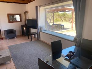 a living room with a window and a table and chairs at Kalamitsi House 1 in Agia Pelagia