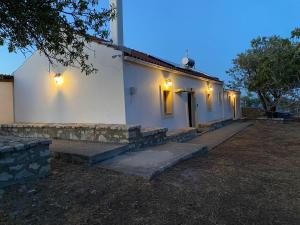 a white building with lights on the side of it at Kalamitsi House 1 in Agia Pelagia