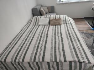 a bed in a room with a striped bedspread at Stan na dan Vanja in Foča