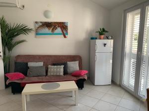 Una sala de estar con un sofá y un refrigerador. en Apartments Filla Novalja, en Novalja