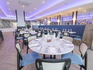 a dining room with white tables and chairs at Luxury Lodge 69 in Rhyl