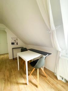 a white table and a chair in a room at StayHere Central City Studio 18 - contactless Self-Check-IN in Graz