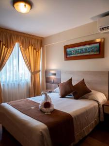 Un dormitorio con una cama grande con un pájaro. en Hotel Britania San Borja, en Lima