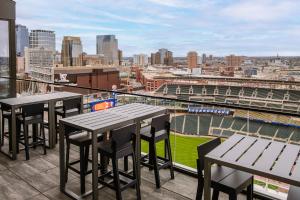 a balcony with tables and chairs and a baseball stadium at Sonder at North Loop Green in Minneapolis