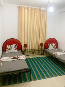 um quarto com duas camas e uma janela em Dream Appartement El Aouina em Tunes