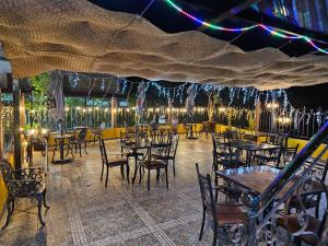 ein Restaurant mit Tischen, Stühlen und Lichtern in der Unterkunft Hotel Peña Florencia in Bernal