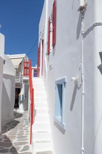 a stairway leading up to a white building with red windows at Chiara Mykonos III in Mýkonos City
