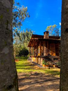 Suite Cabaña Cantodeagua-Jacuzzi في فيلا دي ليفا: كابينة خشبية قديمة في وسط الحديقة