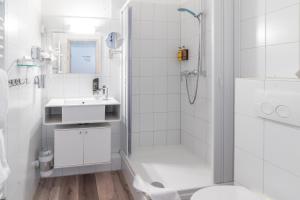 biała łazienka z prysznicem i umywalką w obiekcie Aqua Hotel w Konstancji